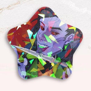 Puede incluir: Pin en forma de estrella con una ilustración estilizada de un personaje con piel morada, ojos rojos y una expresión traviesa. El personaje sostiene un cuchillo. El fondo es una mezcla de formas geométricas rojas, verdes y amarillas.