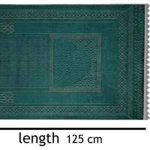 May include: A teal green prayer rug with intricate geometric patterns and tassels on the edges. The rug measures 125 inches long and 80 inches wide.