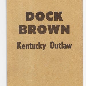 May include: A tan-colored book cover with the title "DOCK BROWN Kentucky Outlaw" printed in black.