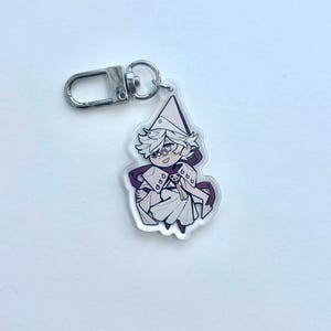 May include: A clear acrylic keychain with a cartoon character in white and purple attire, and a silver clasp. The character has white hair, glasses, and a smiling face. The keychain is designed for attaching to keys or bags.