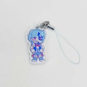 May include: A clear acrylic charm featuring a cartoon character with blue hair and a blue and red outfit. The charm has a silver-colored metal clasp and a light blue lanyard. The character has a red eye and a red bow tie.
