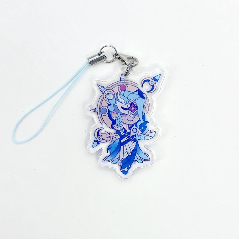 May include: A clear acrylic charm featuring a blue anime-style character with a mask and flowing hair. The charm has a light blue lanyard and a silver clasp for attachment. The character is surrounded by a circular design with purple and blue accents.