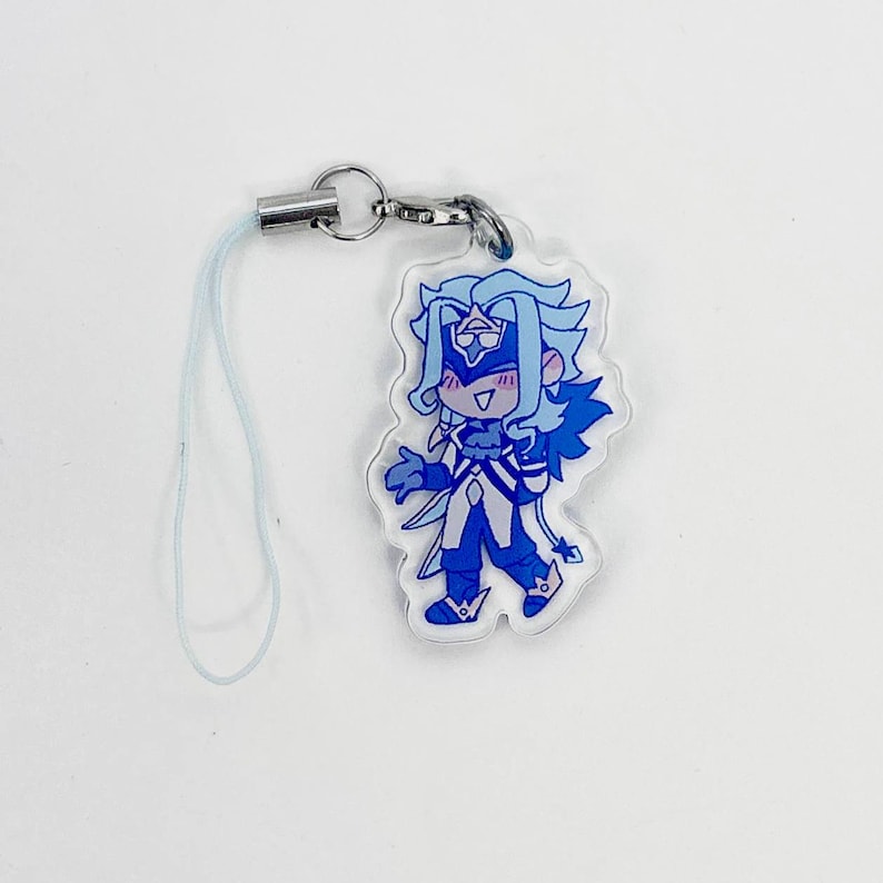 May include: A clear acrylic charm featuring a cartoon character in shades of blue and white. The character has long, light blue hair, a mask, and a detailed outfit. The charm includes a silver-colored metal clasp and a light blue lanyard.