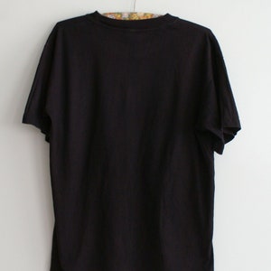 K&ouml;nnte beinhalten: Ein schwarzes T-Shirt mit kurzen &Auml;rmeln und Rundhalsausschnitt.