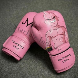 May include: Pink boxing gloves with a cartoon character illustration. The gloves have a hook-and-loop closure and the text "YOUR NAME LOGO". The left glove has a black "M" design.