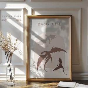 May include: A gold framed poster with a light blue background and three brown dragon silhouettes. The poster has the text "BASGIATH" at the top.
