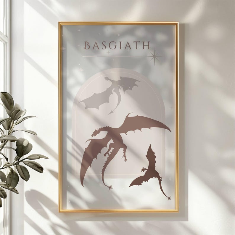 May include: A framed print with a light blue background and the word "BASGIATH" in black text. Three brown dragon silhouettes are flying in a circular archway with a star in the top right corner.
