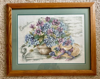 Handmade finished cross stitch. Flowers and a hat.