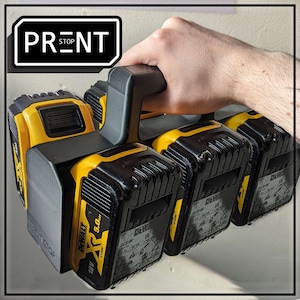 May include: A black and yellow battery holder with the text "PRENT STOP" on the front. The holder has four slots for batteries and a handle on the top. The batteries are labelled "DEWALT 18V 5.0 Ah".