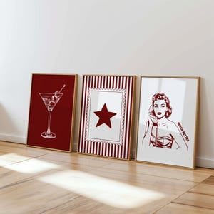 Könnte beinhalten: Drei gerahmte Kunstdrucke mit Retro-Motiven. Einer zeigt ein weißes Martiniglas mit Oliven auf rotem Hintergrund. Ein anderer hat einen roten Stern auf gestreiftem Hintergrund. Der dritte Druck zeigt eine Frau am Telefon mit dem Text "NEVER BETTER".