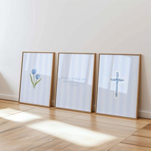 May include: Three framed prints with light blue and white striped backgrounds. One print features blue tulips, another has the text "God is within her, she will not fail," and the third displays a blue cross.