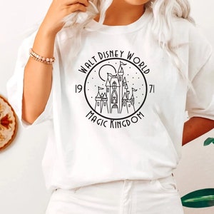 Puede incluir: Camiseta blanca con un gr&aacute;fico negro del castillo de Cenicienta y el texto "Walt Disney World 1971 Magic Kingdom".