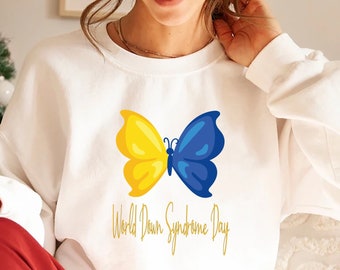 May include: White sweatshirt with a yellow and blue butterfly graphic and the text "World Down Syndrome Day" in gold lettering.