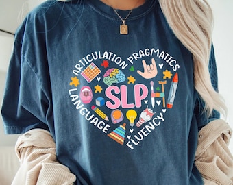 May include: A dark blue t-shirt with a heart-shaped design featuring the word "SLP" surrounded by illustrations of speech therapy related items and the words "Articulation", "Pragmatics", "Language", and "Fluency".