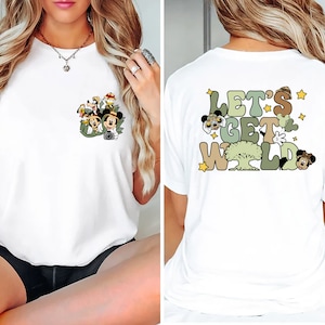 May include: White t-shirt with a pocket featuring a cartoon image of Mickey Mouse and friends in a jungle setting. The back of the shirt has a graphic that says "Let's Get Wild" with cartoon images of Mickey Mouse and friends.