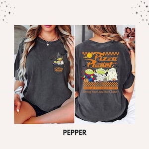 Pode incluir: Camiseta cor pimenta com um design Pizza Planet. O bolso frontal tem um gr&aacute;fico de alien&iacute;genas e o logotipo Pizza Planet. A parte de tr&aacute;s exibe o logotipo Pizza Planet e personagens com o texto "FOOD & FUN SPACE PORT Serving Your Local Star Cluster!"