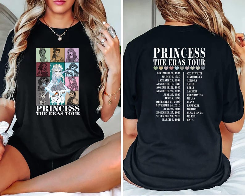 May include: Black t-shirt with a graphic of Disney princesses and the text "Princess The Eras Tour". The back of the shirt has a list of princesses and their corresponding movie release dates.