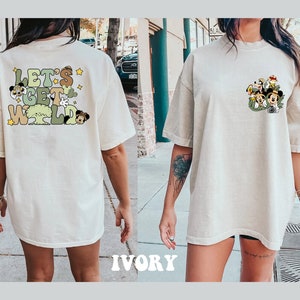 May include: A white oversized t-shirt with a graphic print of cartoon characters and the text "Let's Get Wild".