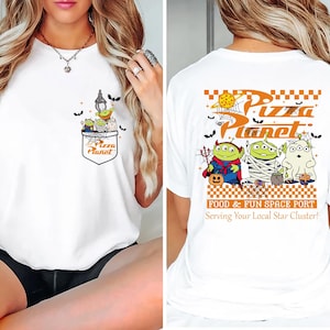 Pode incluir: Camiseta branca com um design Pizza Planet com tema de Halloween. O bolso frontal tem um gr&aacute;fico de alien&iacute;genas e o logotipo Pizza Planet. A parte de tr&aacute;s exibe o logotipo Pizza Planet, alien&iacute;genas fantasiados e o texto "Food & Fun Space Port".