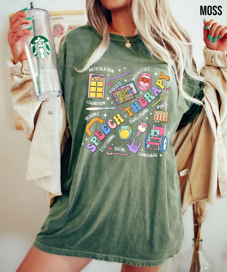 May include: Green t-shirt with a colorful graphic design that says "Speech Therapy" and includes icons representing different aspects of speech therapy, such as articulation, cognition, hearing, swallowing, stuttering, social, language, and voice.