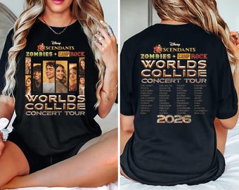 May include: Black t-shirt featuring the text "Descendants Zombies + Camp Rock Worlds Collide Concert Tour" in gold and white. The front of the shirt displays images of the cast. The back lists tour cities and the year 2026.
