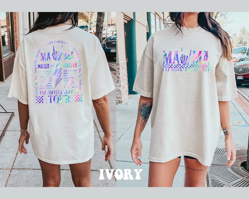 May include: A white oversized t-shirt with a holographic graphic on the front that says "MAMA" with a sign language hand symbol for "I love you". The back of the shirt has a holographic graphic that says "MAMA MAKES IT ALL HAPPEN" with a sign language hand symbol for "I love you" and the text "THE MOTHERLODE TOUR".