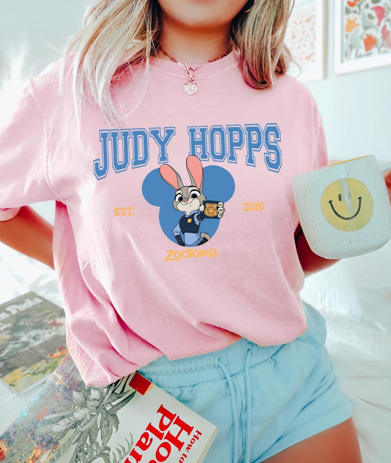 Op de afbeelding: Een witte keramische mok met een zwart handvat en de tekst "But First, Coffee" in een zwarte, vette letter. De mok staat op een houten oppervlak. De mok is ongeveer 10 cm hoog.