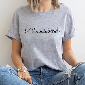 May include: A gray t-shirt with the word "Alhamdulillah" written in black cursive script.