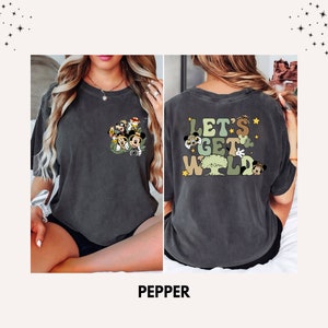 May include: A dark gray t-shirt with a graphic print of Mickey Mouse and friends on the front and the text "Let's Get Wild" on the back. The graphic features Mickey Mouse, Minnie Mouse, Donald Duck, Goofy, and Pluto.