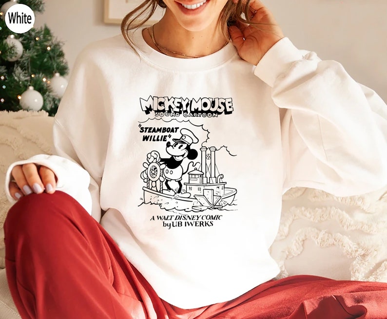 K&ouml;nnte beinhalten: Wei&szlig;es Sweatshirt mit einer Schwarzwei&szlig;illustration von Mickey Mouse als Dampfschiffkapit&auml;n. Der Text "Mickey Mouse Sound Cartoon" befindet sich &uuml;ber dem Bild und "Steamboat Willie" unter dem Bild. Der Text "A Walt Disney Comic by UB Iwerks" befindet sich am unteren Rand des Bildes.