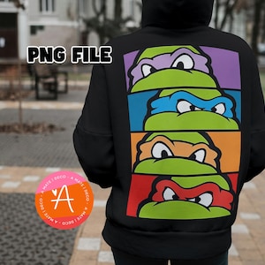 Puede incluir: Sudadera con capucha negra con un diseño colorido de las Tortugas Ninja. El diseño presenta las caras de las tortugas en verde, con máscaras y fondos de colores. El texto "PNG FILE" está en la parte superior.