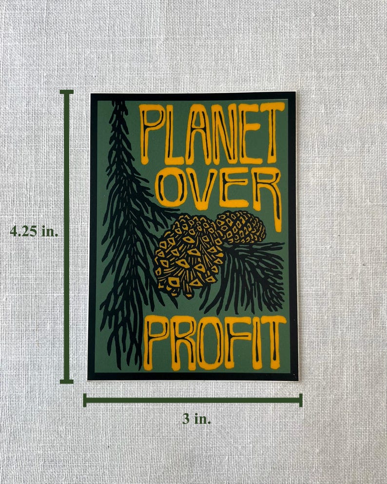 May include: A rectangular sticker with the text "PLANET OVER PROFIT" in yellow, set against a green background. The design includes a pine branch and two pinecones. The sticker measures 4.25 inches by 3 inches.
