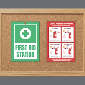 May include: A corkboard with a wooden frame displays a green and white "First Aid Station" sign and a red fire extinguisher guide. The fire extinguisher guide shows the PASS technique: Pull, Aim, Squeeze, Sweep.