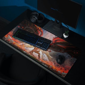 May include: A black and red gaming mouse pad with a colorful illustration of a warrior and a dragon. The mouse pad is on a black desk with a keyboard, a headset, and a computer monitor.
