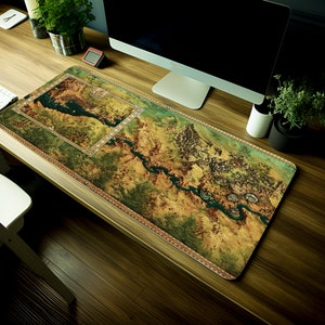May include: A large, detailed map of a fantasy world printed on a brown and green mouse mat. The map features rivers, mountains, and cities.