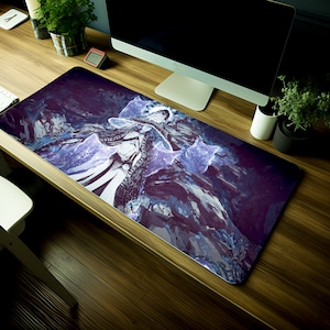 May include: A purple and blue gaming mouse pad with a stylized image of a figure in a long white robe with a hood and a staff. The figure is surrounded by glowing blue stars.