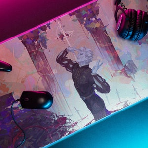 May include: Gaming mouse mat featuring a colourful illustration of a figure in a black and white outfit. A black gaming controller, mouse, and headphones are also visible. The mat has a blue and pink border.