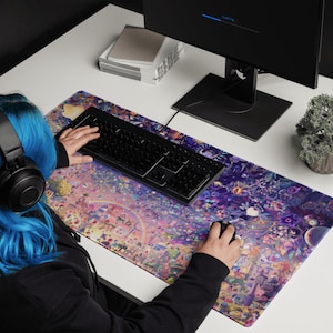 Puede incluir: Una persona usando un teclado y un rat&oacute;n negros sobre una alfombrilla de rat&oacute;n grande y colorida con un dise&ntilde;o detallado y caprichoso. La alfombrilla de rat&oacute;n presenta una variedad de personajes y objetos, incluyendo un arco&iacute;ris, estrellas y flores.