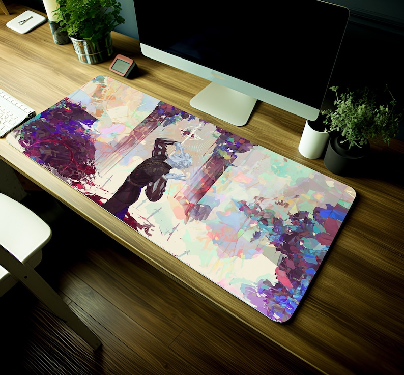 May include: A rectangular mouse mat with an abstract art design. The artwork features a figure in black and white, with splashes of purple, blue, and green. The mat is designed to sit under a keyboard and mouse, and measures approximately 80cm in length.