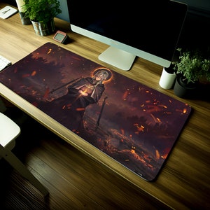 May include: A large, rectangular gaming mouse pad with a dark background and a fantasy illustration of a figure in a hooded cloak holding a glowing orb. The figure is surrounded by a swirling mist and glowing embers.