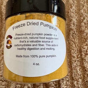 Powdered freeze dried pumpkin with 2 free feeder dishes and a spoon.