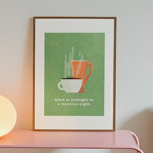 May include: Framed art print with two coffee cups on a green backdrop. One cup is white, the other orange. The text reads "black as midnight on a moonless night."