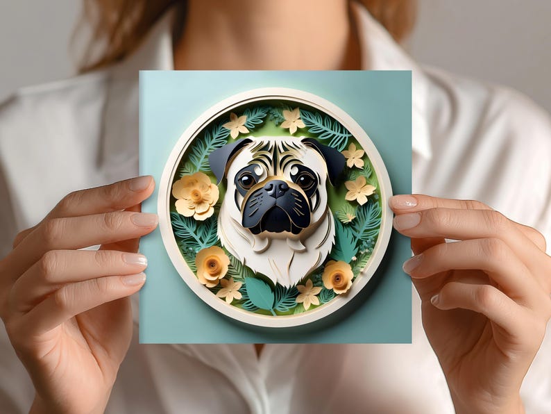 May include: A square, light blue card featuring a 3D illustration of a pug dog within a circular frame. The pug has a cream-colored face, black ears, and a black snout. The frame is decorated with yellow flowers and green leaves.
