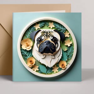 May include: A greeting card featuring a pug's face in a circular design. The pug is cream, black, and brown, surrounded by paper flowers and leaves. The card is on a light blue background, with a tan envelope.