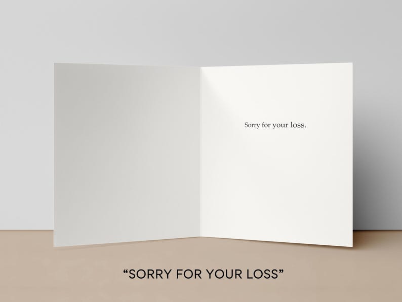 May include: A blank, folded greeting card with the text "Sorry for your loss." printed in black. The card is open, revealing the inside, and is set against a neutral background. The words "SORRY FOR YOUR LOSS" are at the bottom.