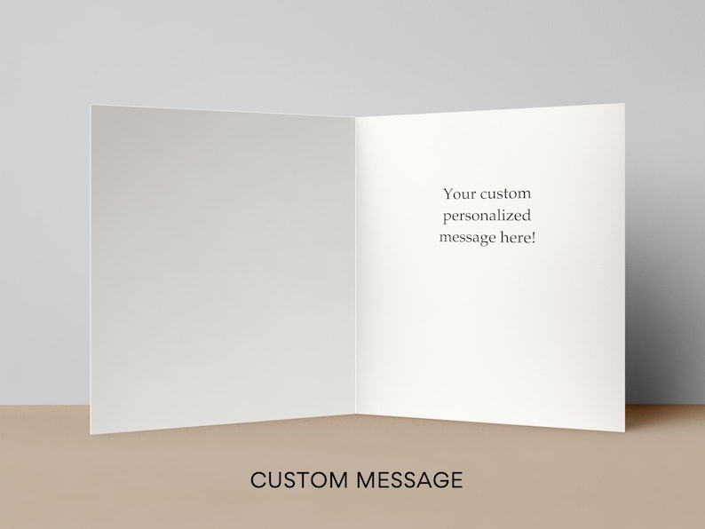 May include: An open, blank greeting card with the text "Your custom personalized message here!" on the right side. The words "CUSTOM MESSAGE" are at the bottom. The card is white and sits on a tan surface.