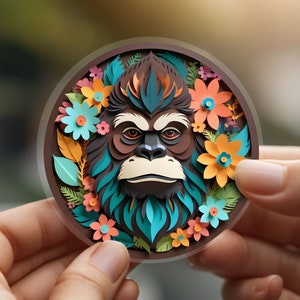 May include: A paper craft of an orangutan's face surrounded by colorful flowers and leaves. The orangutan has brown fur, a blue and green beard, and a serious expression.