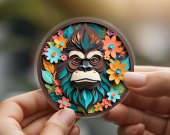 May include: A paper craft of an orangutan's face surrounded by colorful flowers and leaves. The orangutan has brown fur, a blue and green beard, and a serious expression.