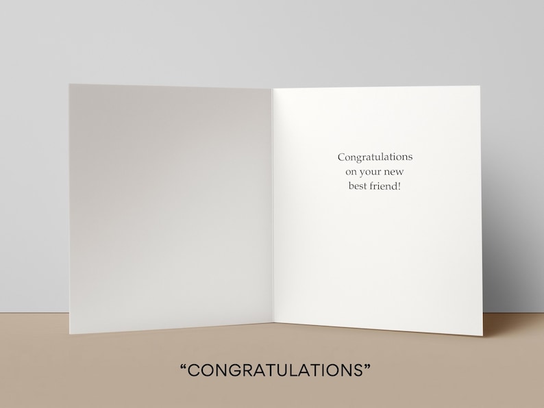 May include: An open greeting card with the text "Congratulations on your new best friend!" on the right panel. The bottom of the image displays the word "CONGRATULATIONS" in quotation marks. The card is white with a neutral background.