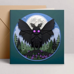 May include: A square greeting card featuring a black moth with purple eyes, set against a backdrop of a full moon, forest, and clouds. The card is surrounded by a blue border and comes with a tan envelope.